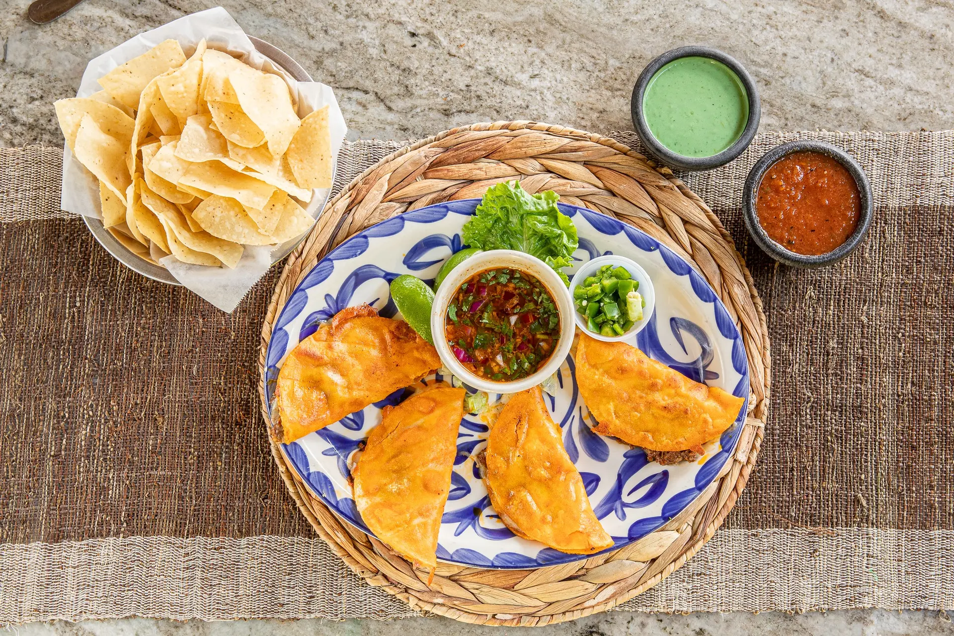 Birria tacos with consommé, jalapeños, chips and salsa